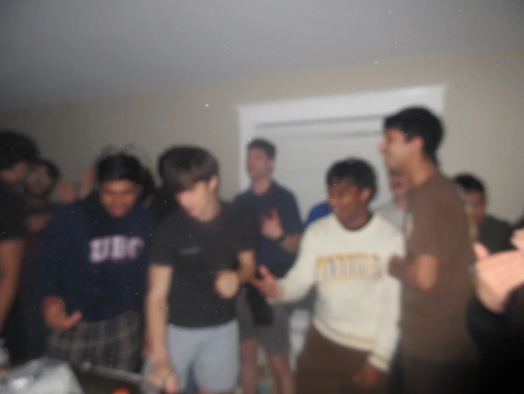 Crowd gathered around the DJ booth at a house party
